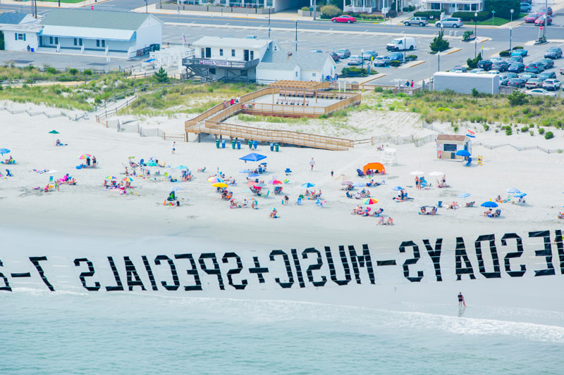 Aerial Photo Advertising Aerial Banner w Beach in Background