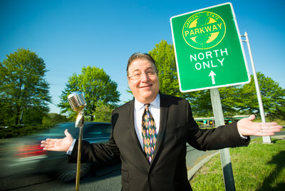 Photo of Vinnie Favale with a microphone standing on the side of the Garden State Parkway