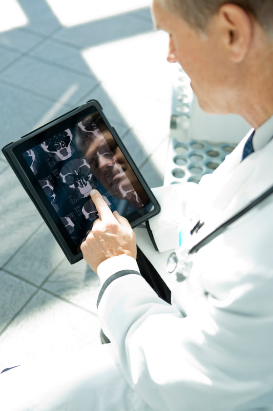 Medical Doctor examine X-Rays on tablet