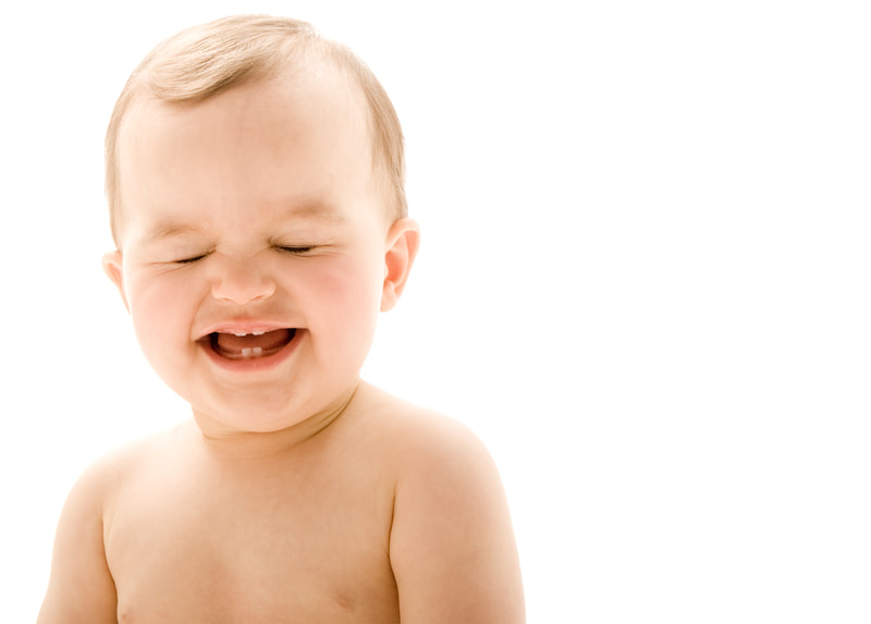 Photograph of a caucasian baby boy laughing on white seamless background
