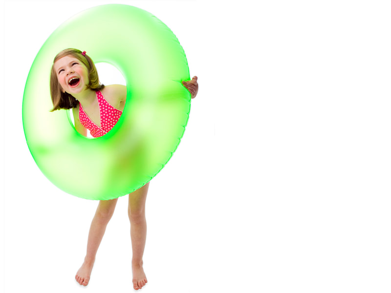 Photograph of a girl in swimsuit with a green inner tube on white seamless background